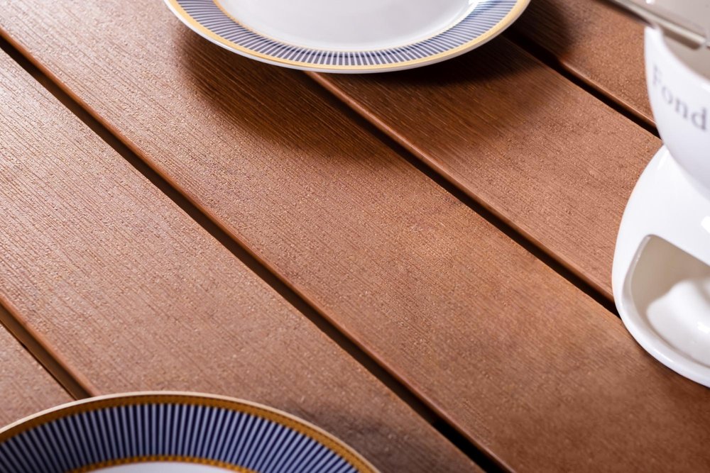 35" White Heavy Duty Plastic Square Outdoor Dining Table with Umbrella Hole styled in a furnished interior with a blush wall on a dark wood floor.