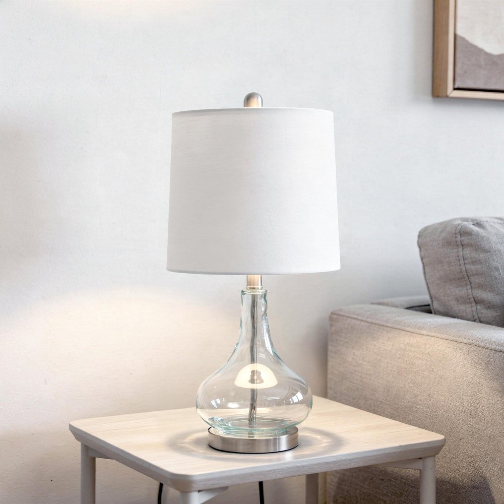 23" Teal Blue Translucent Glass Gourd Table Lamp With Drum Shade displayed on a tabletop in a furnished interior against an off-white wall.