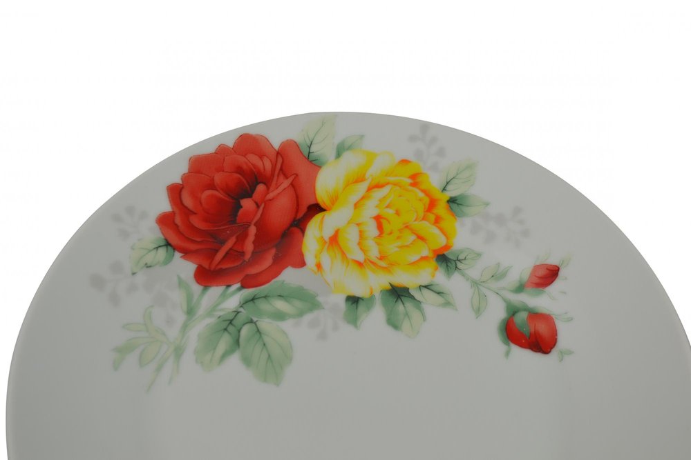 White ceramic dinnerware set with red and yellow roses and buds, on a white background.