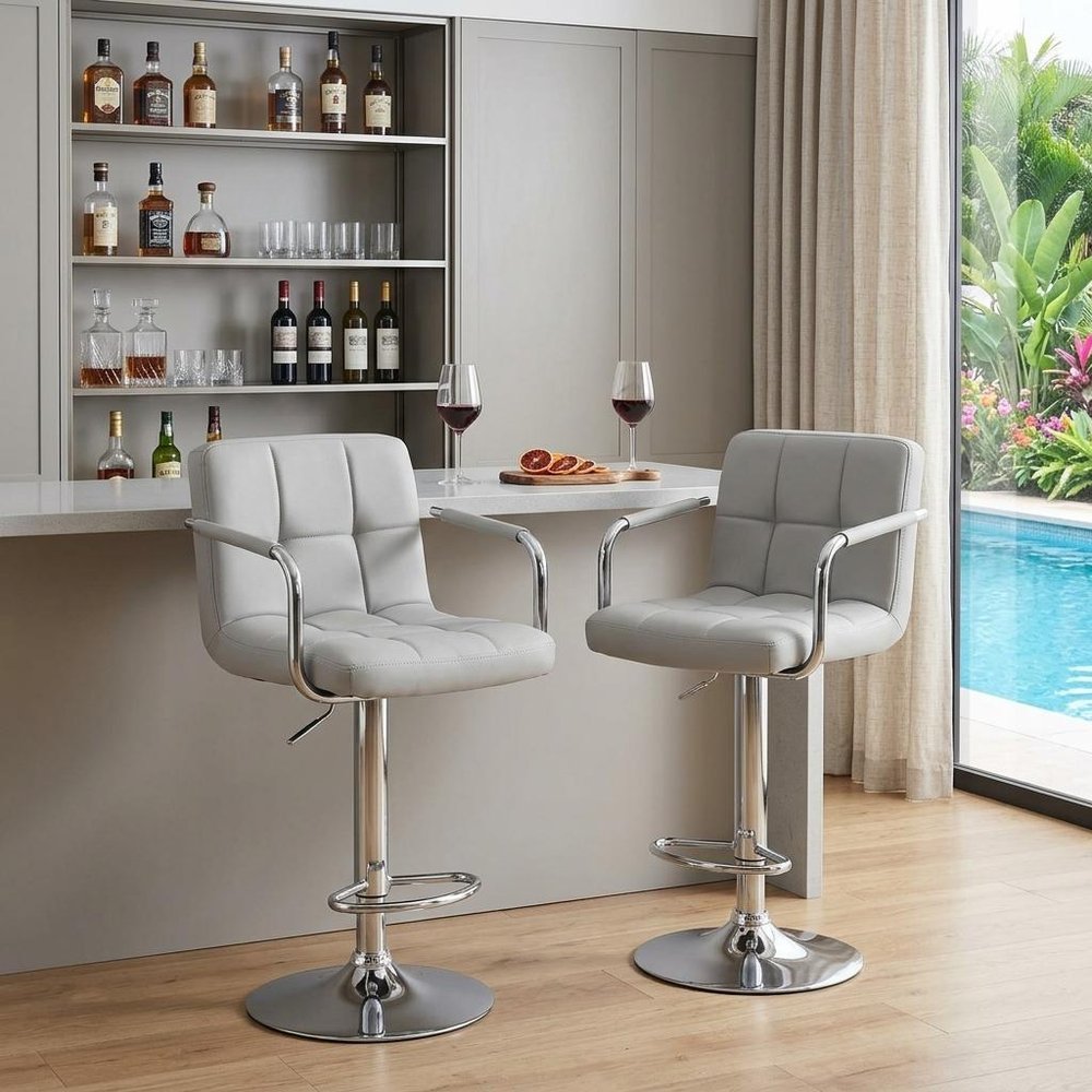 Set of Two Black And Silver Faux Leather And Aluminum Adjustable Height Swivel Bar Chairs in a home interior