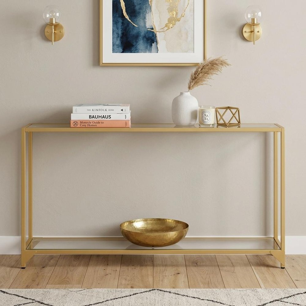 56" Clear and Gold Glass and Iron Console Table With Shelf. Console table isolated on a plain white background, finished in gold glass.