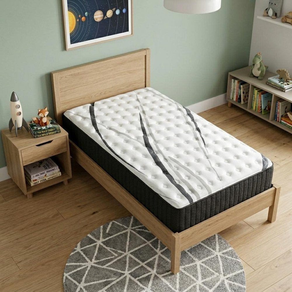 14" Graphite And Titanium Infused Twin Gel Memory Foam Firm Hybrid Mattress styled in a furnished interior with a light gray wall on a wood floor.