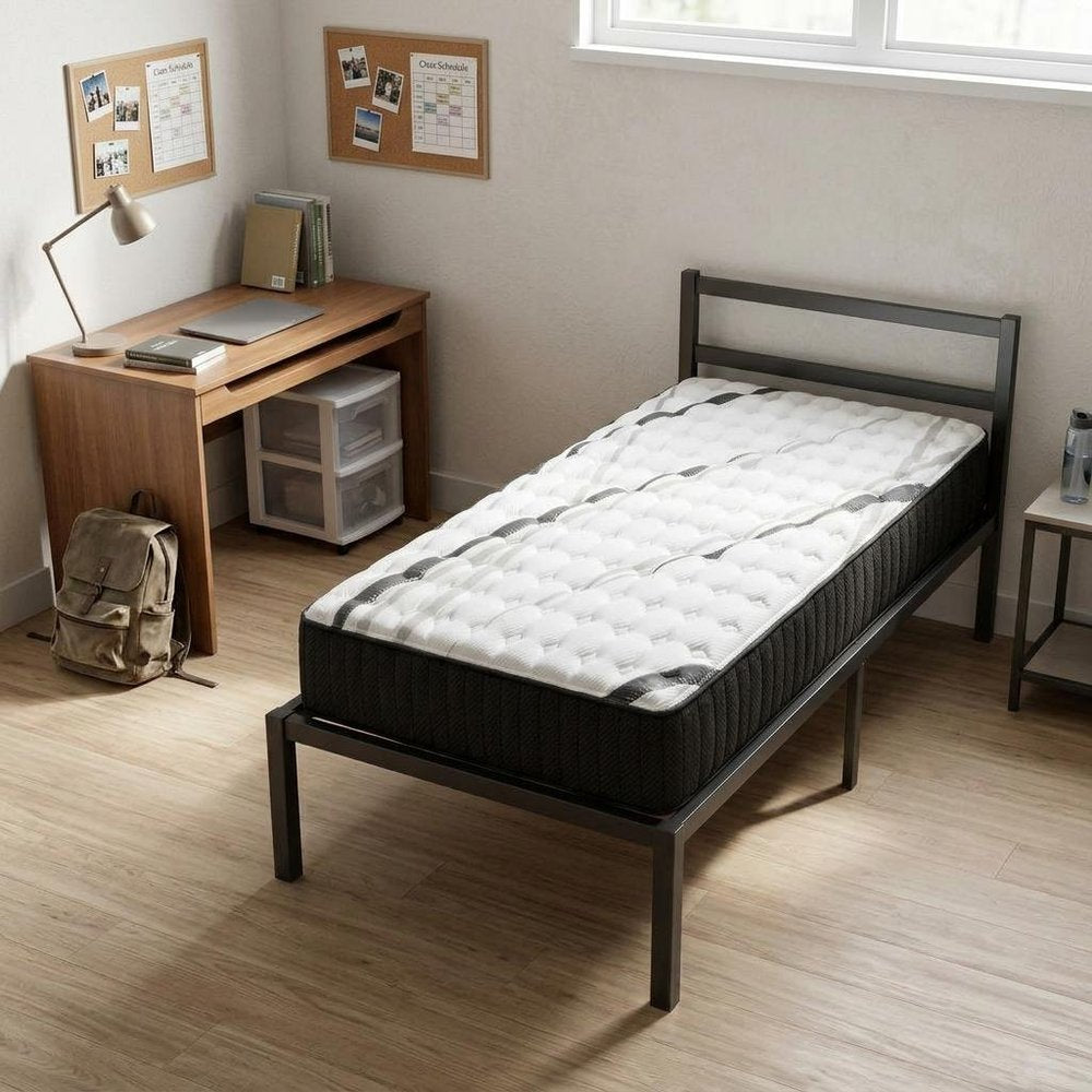14" Graphite And Titanium Infused Twin Gel Memory Foam Firm Hybrid Mattress styled in a furnished interior with a tan wall on a dark wood floor.