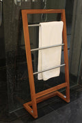 45" Brown And Silver Stainless Steel And Teak Towel Stand photographed against a dark studio background in brown.