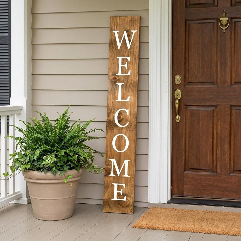 59" Natural And White Solid Wood Welcome Porch Sign shown outdoors on a patio with greenery.