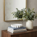 2" Cream Marble Decorative Bowl styled in a furnished interior with an off-white wall on a dark wood floor.