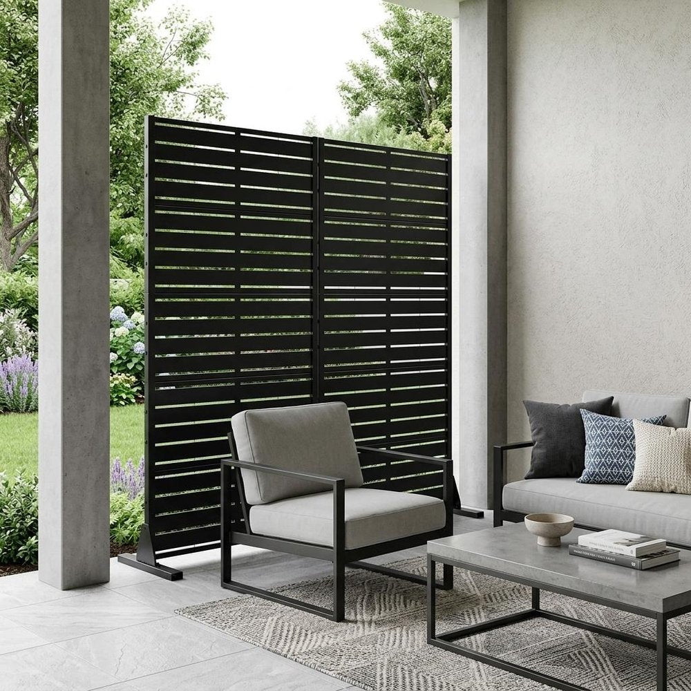 59" Black Steel 20 Panel Outdoor Privacy Screen shown outdoors on a tiled patio with greenery.