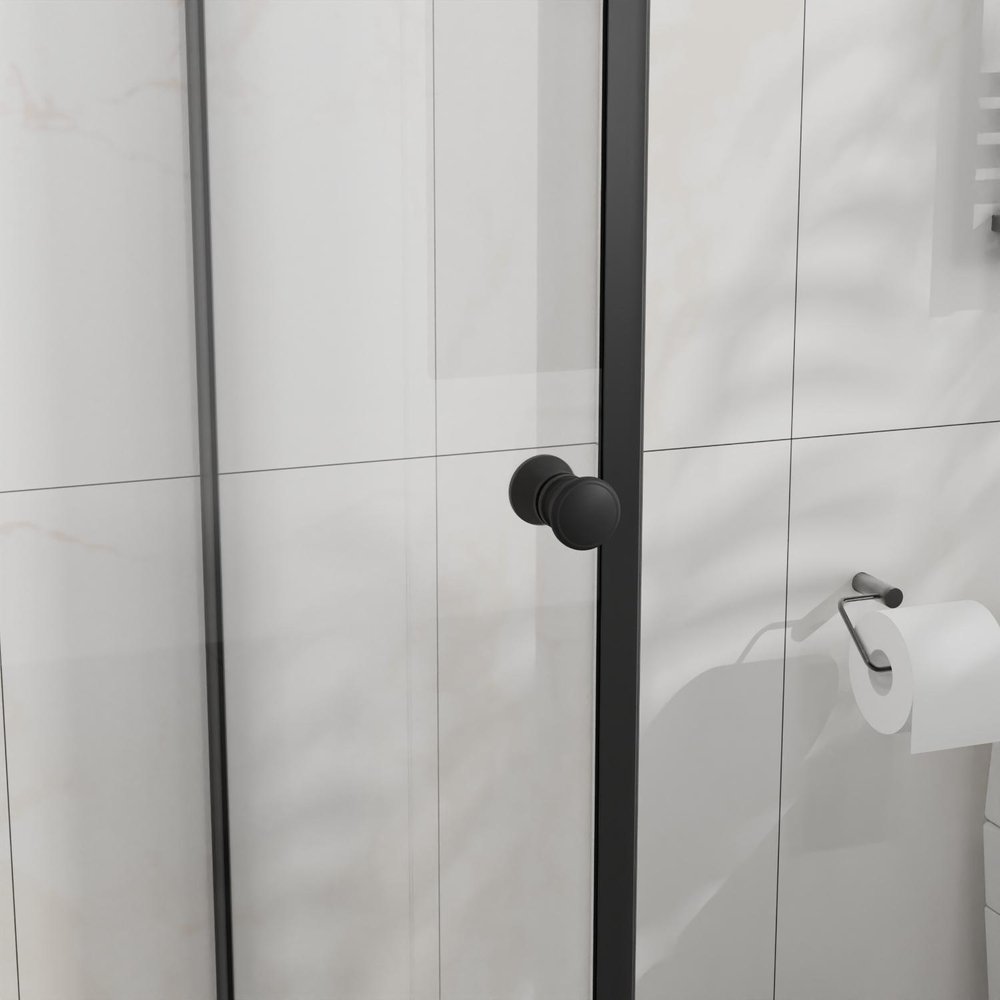 Black handle on a clear glass shower door with white tiled background and a toilet paper holder.