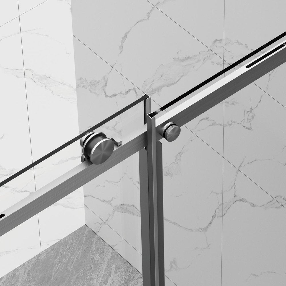 Close-up of a brushed nickel sliding shower door with rollers against a marble tiled wall.