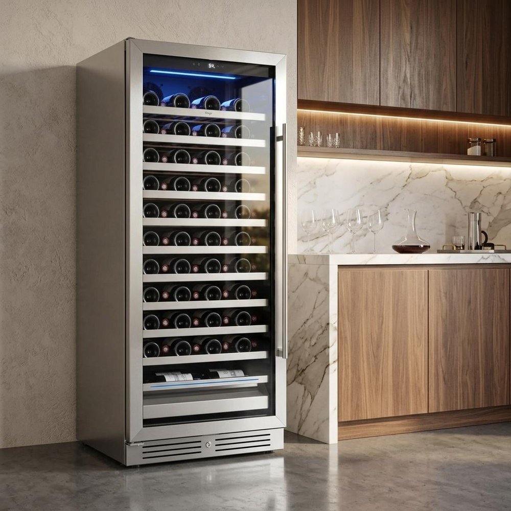 55" X 23" Silver and Black Stainless Steel Single Compartment Wine Refrigerator styled in a furnished interior with a tan wall on a tiled floor.