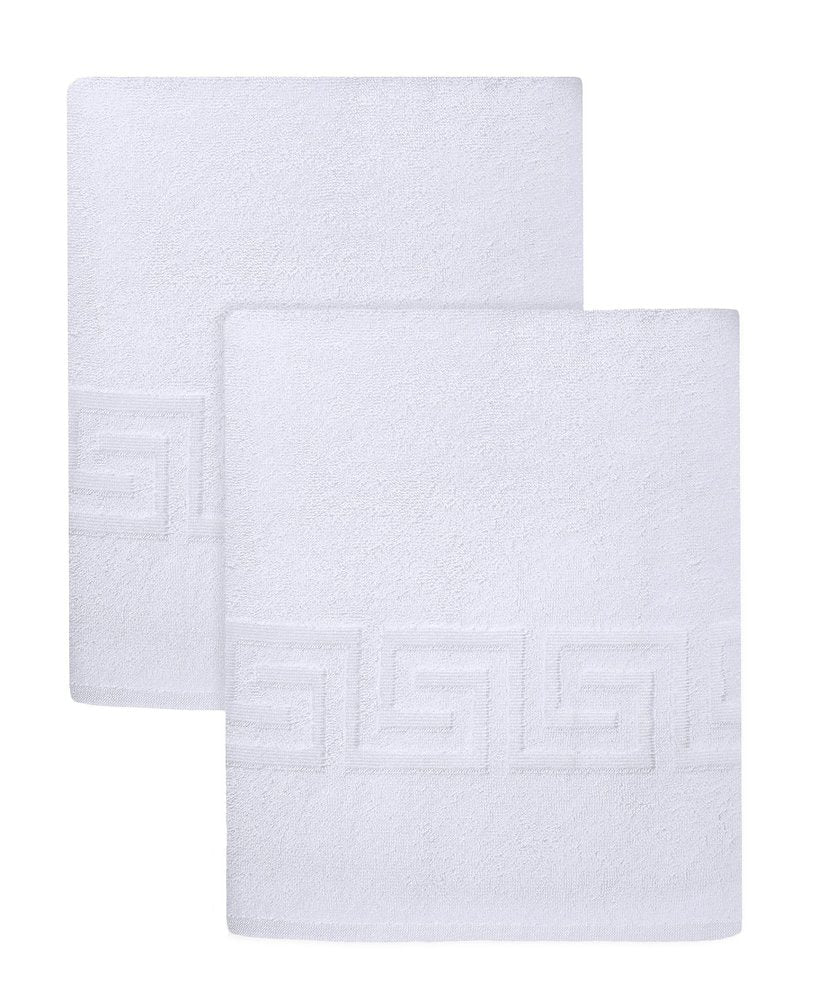 Two white Turkish cotton bath sheets with a Greek key border, stacked on a white background.